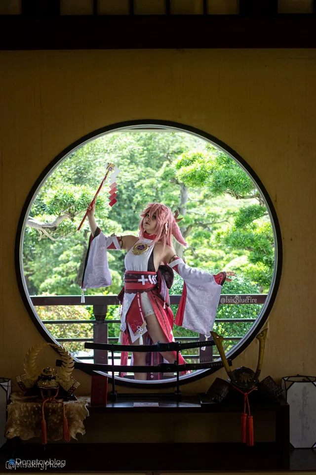 Beautiful Yae Miko against green foliage